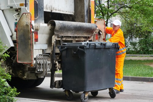 Worker preparing a commercial bin for collection with clear signage for accessibility